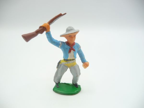 Cowboy standing, holding up rifle