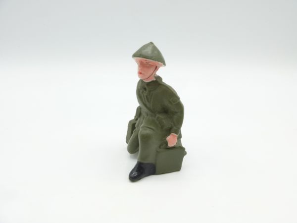 Soldier kneeling with ammunition case