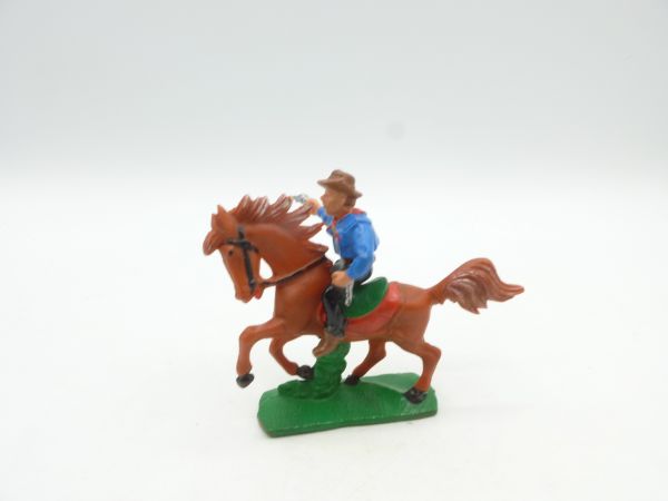 Cowboy riding, shooting pistol, blue shirt