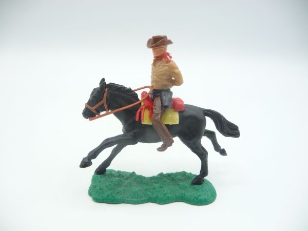 Cowboy riding with hands tied behind his back, beige
