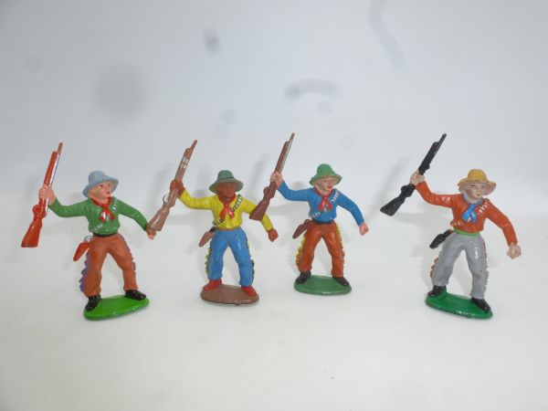 4 Cowboys holding up rifle