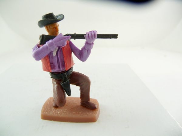 Plasty Cowboy kniend mit losem Gewehr schießend