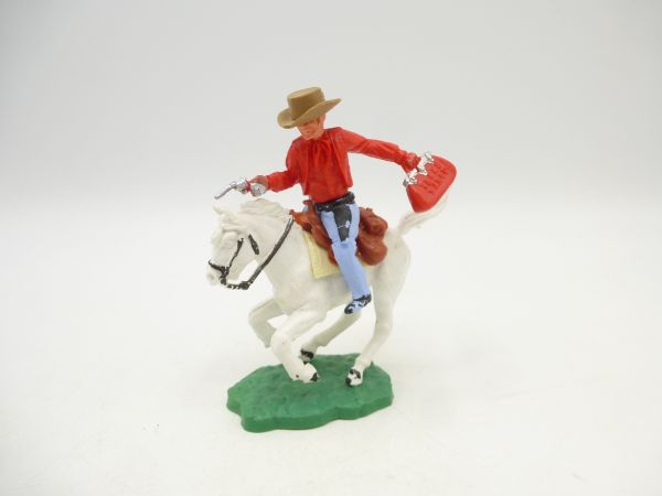 Timpo Toys Cowboy 1. Version (rot) reitend mit Pistole + Geldtasche