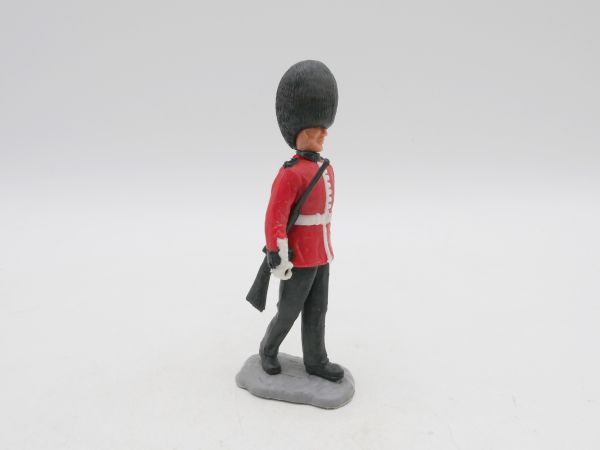 Timpo Toys Guardsman walking, rifle sideways under his arm