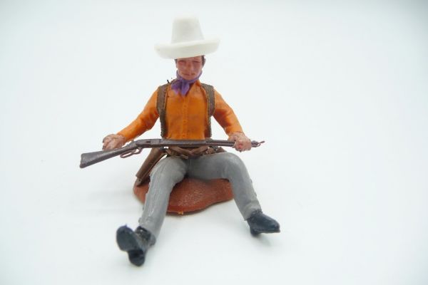 Britains Swoppets Cowboy sitzend mit Gewehr, Hemd orange