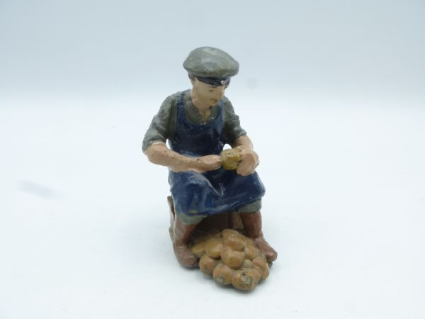 Figure sitting, peeling potatoes, unmarked