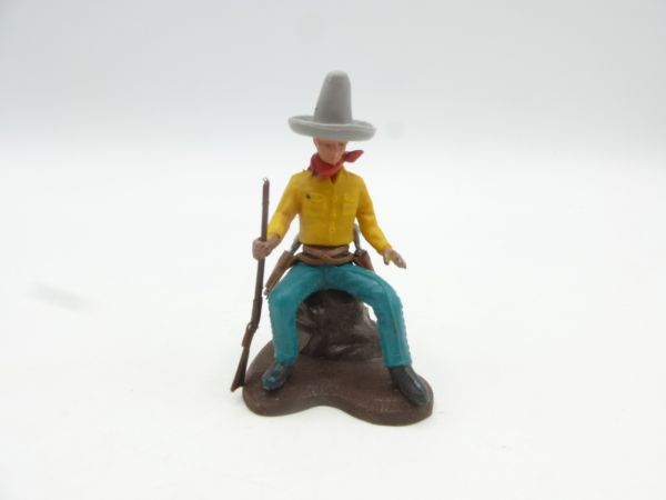 Britains Swoppets Cowboy sitting on tree trunk, rifle at side