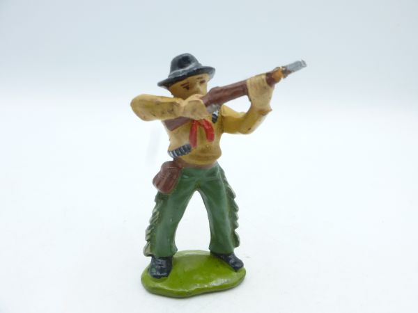 Cowboy standing, shooting rifle upwards
