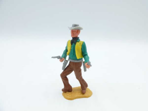 Timpo Toys Cowboy stehend mit 2 Pistolen, grünes Hemd, gelbe Weste