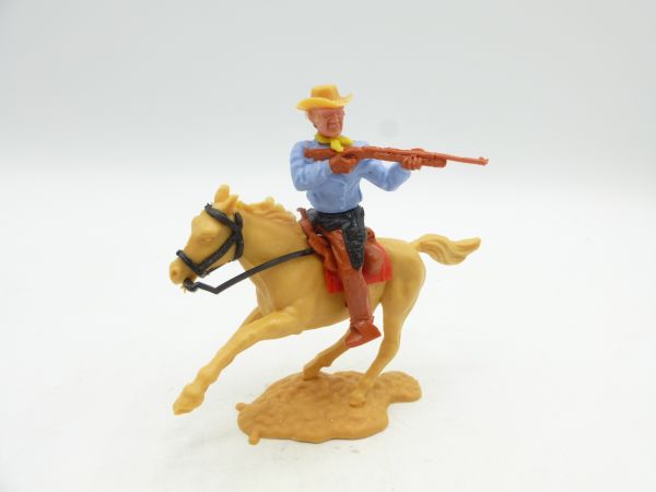 Timpo Toys Cowboy reitend, mit Gewehr schießend (hellblaues Hemd)