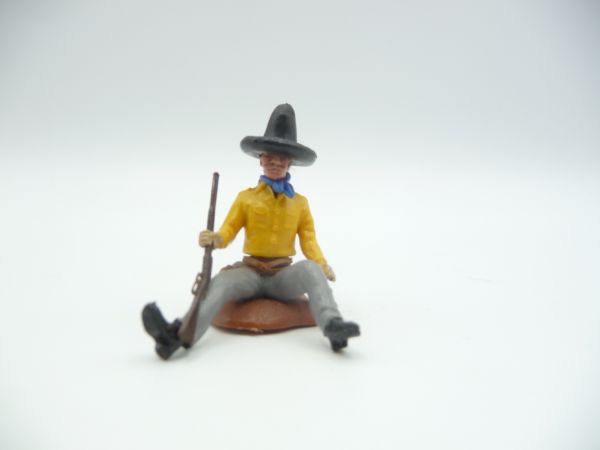 Britains Swoppets Cowboy sitting at a trunk, rifle resting on his side