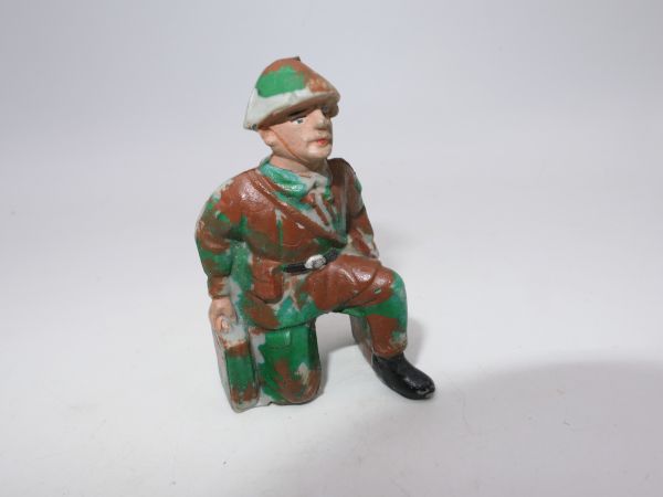 Soldier (camouflage spot uniform) kneeling with 2 ammunition cases